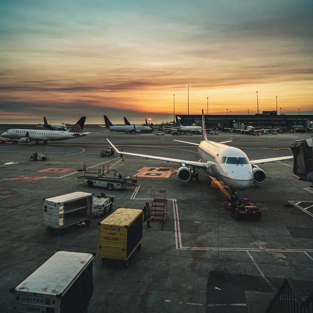 Avions parqués sur un tarmac d'aéroport au coucher du soleil