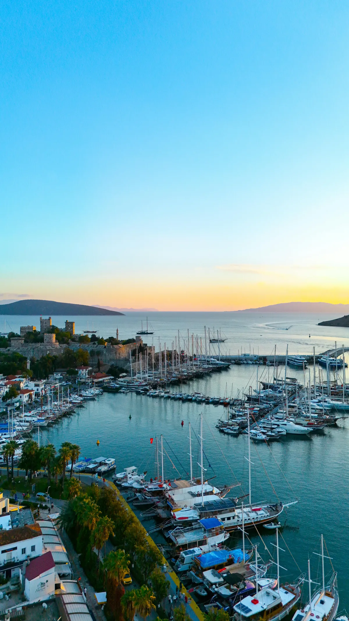 Marina de Bodrum au coucher de soleil avec yachts et chateau