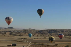 Montgolfières colorées survolant les cheminées de fée de Cappadoce au lever du soleil
