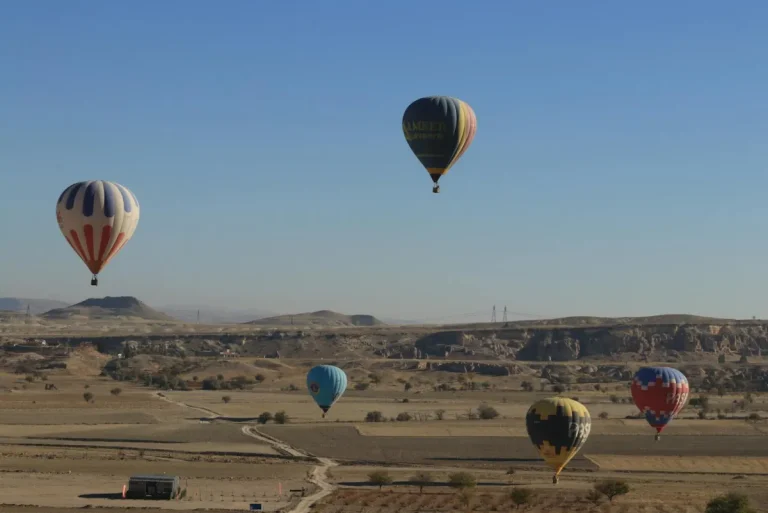 Montgolfières colorées survolant les cheminées de fée de Cappadoce au lever du soleil