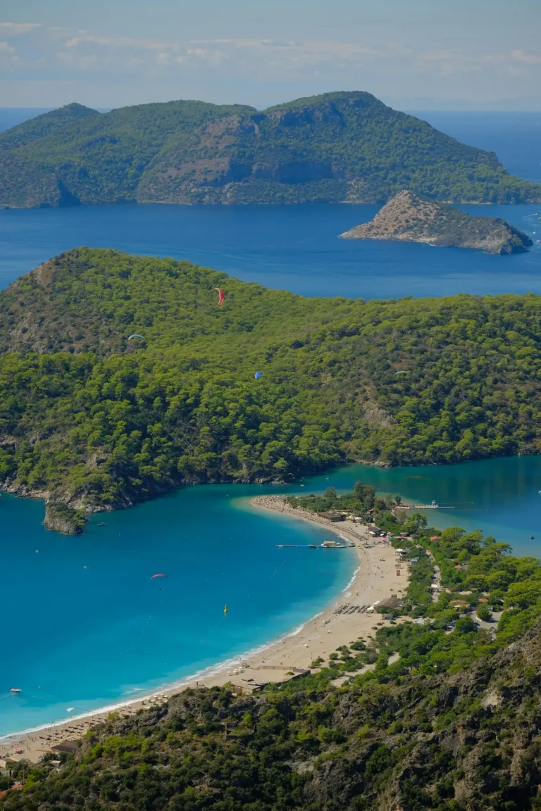 Lagon bleu d'Oludeniz vu depuis Babadag, banc de sable en arc de cercle separant le lagon turquoise de la mer ouverte, parapentes dans le ciel