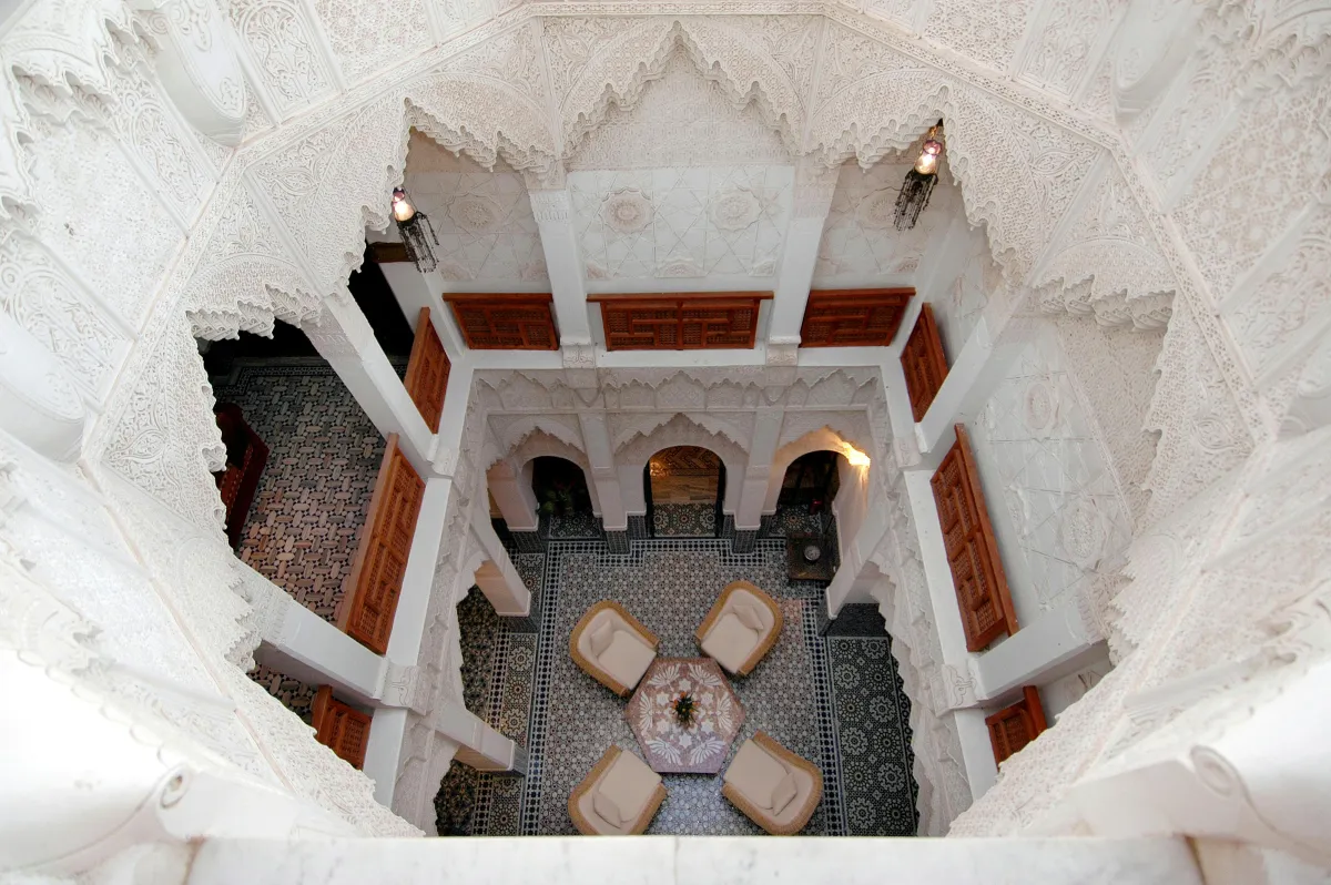 Patio traditionnel d'un riad marocain à Marrakech avec mosaïques zellige