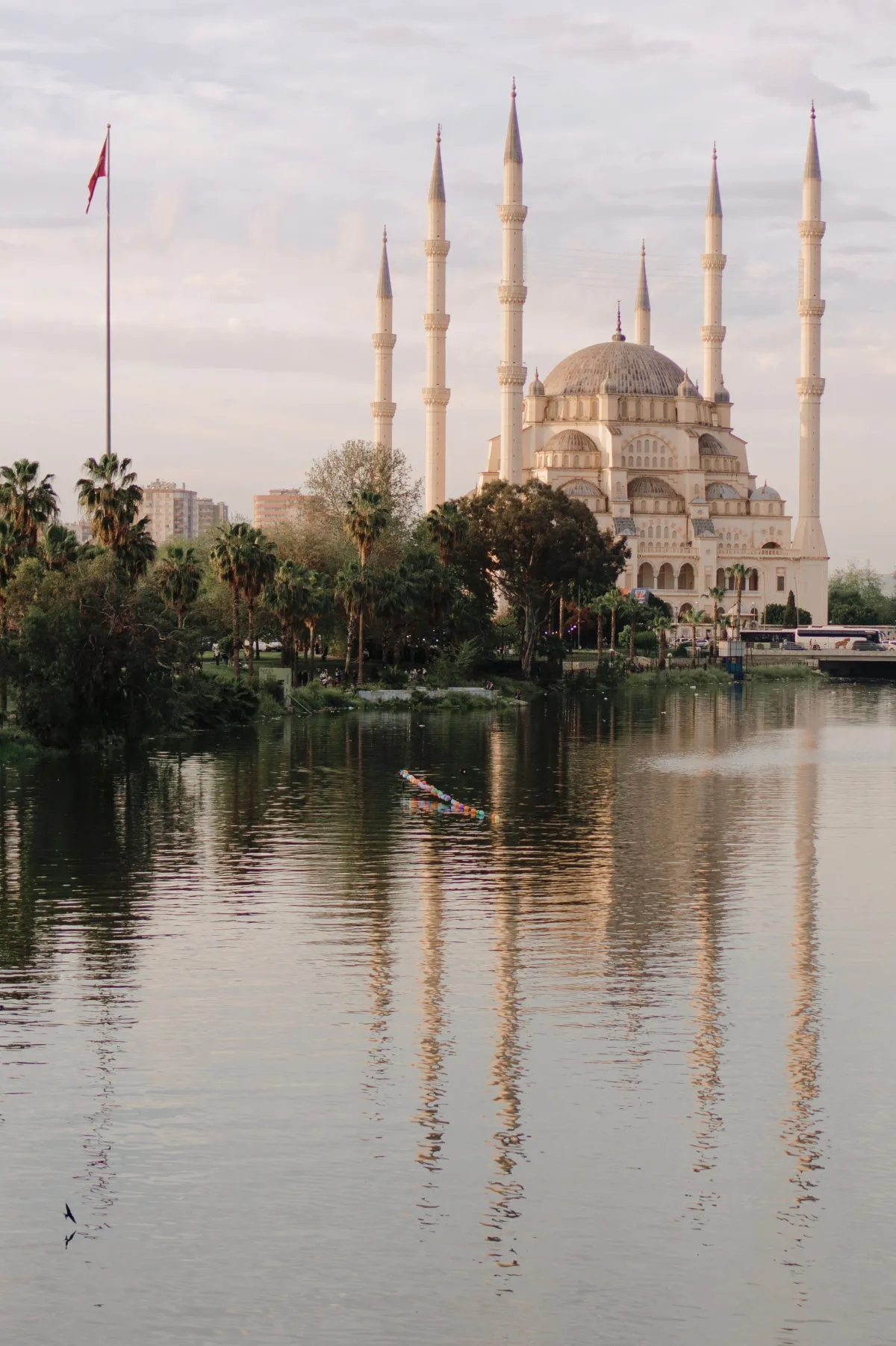 Mosquée Sabancı d'Adana au coucher du soleil reflétée dans la rivière Seyhan
