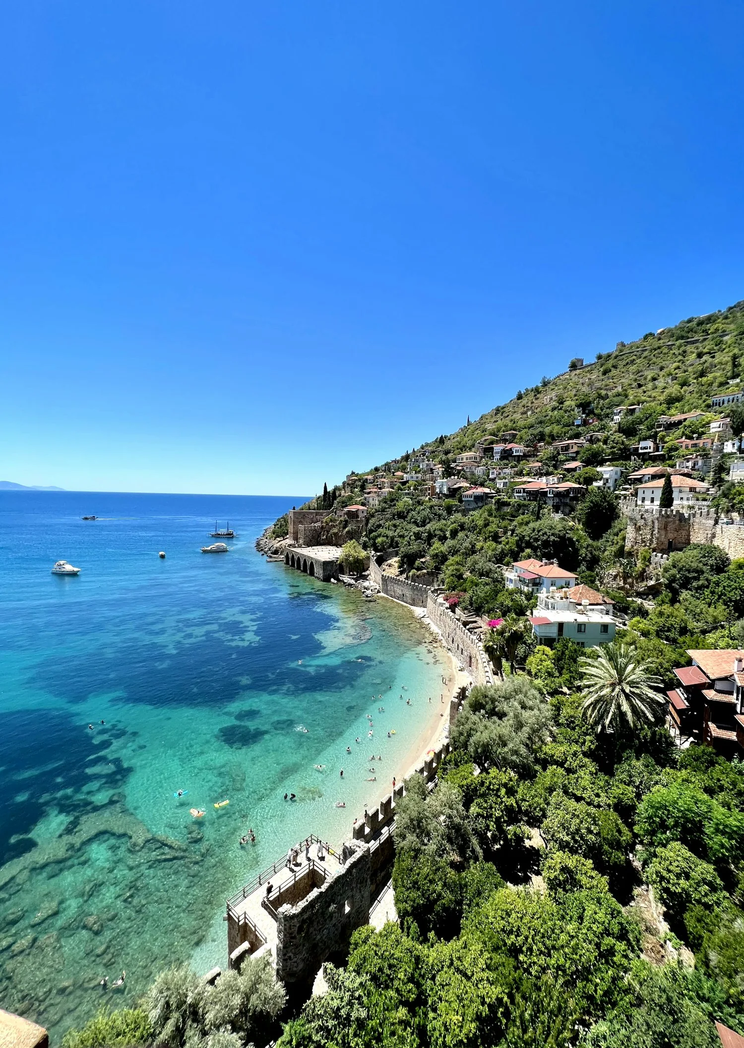Remparts du château seldjoukide d'Alanya descendant vers une crique aux eaux turquoise
