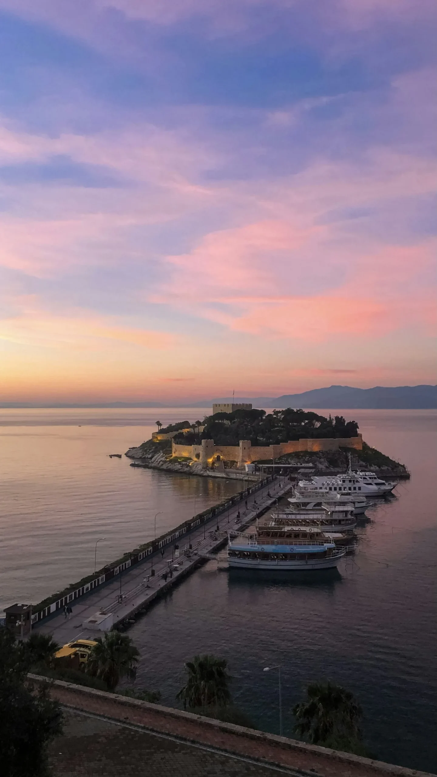 Île aux Pigeons de Kuşadası et son château des pirates au coucher du soleil, avec les bateaux d'excursion