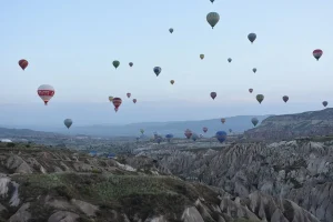 Une trentaine de montgolfieres en vol au petit matin au-dessus de vallees de tuf clair