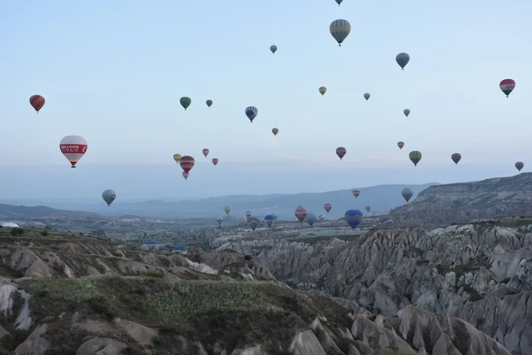 Une trentaine de montgolfieres en vol au petit matin au-dessus de vallees de tuf clair
