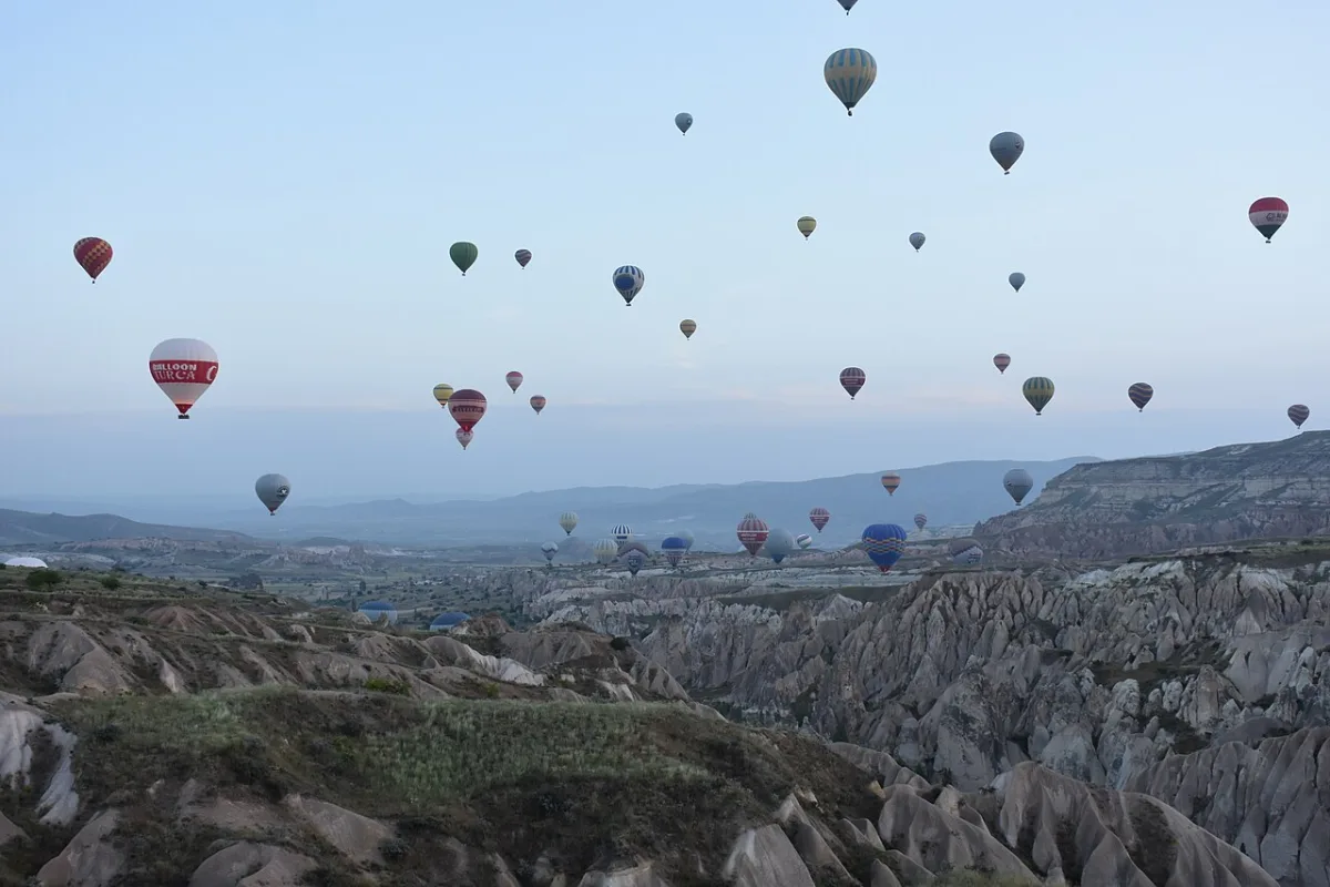 Une trentaine de montgolfieres en vol au petit matin au-dessus de vallees de tuf clair