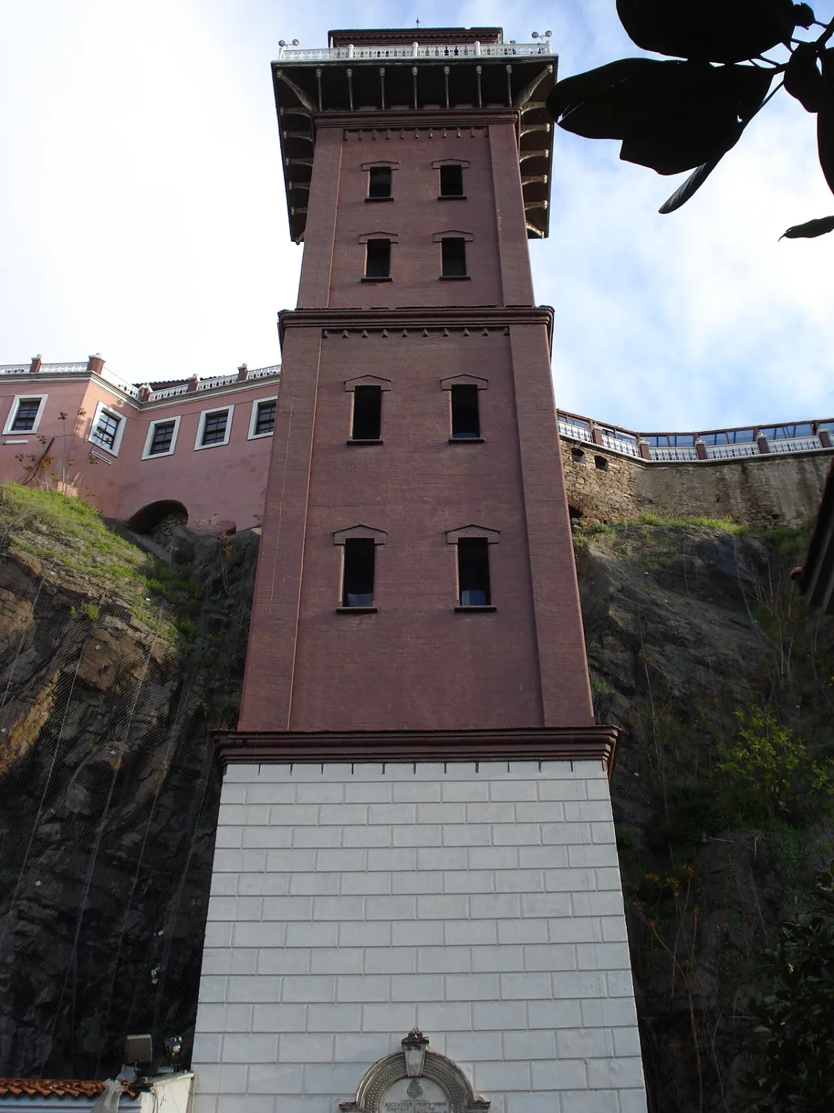 Tour de brique adossee a une falaise, terrasse a son sommet, vue en contre-plongee