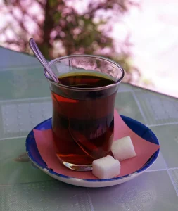 Verre de thé turc en forme de tulipe avec deux morceaux de sucre