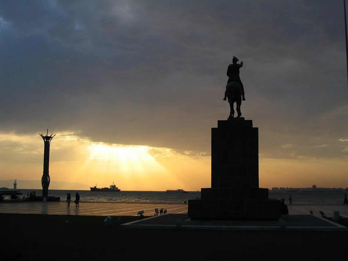 Coucher de soleil orange sur le golfe d'Izmir, statue equestre en contre-jour
