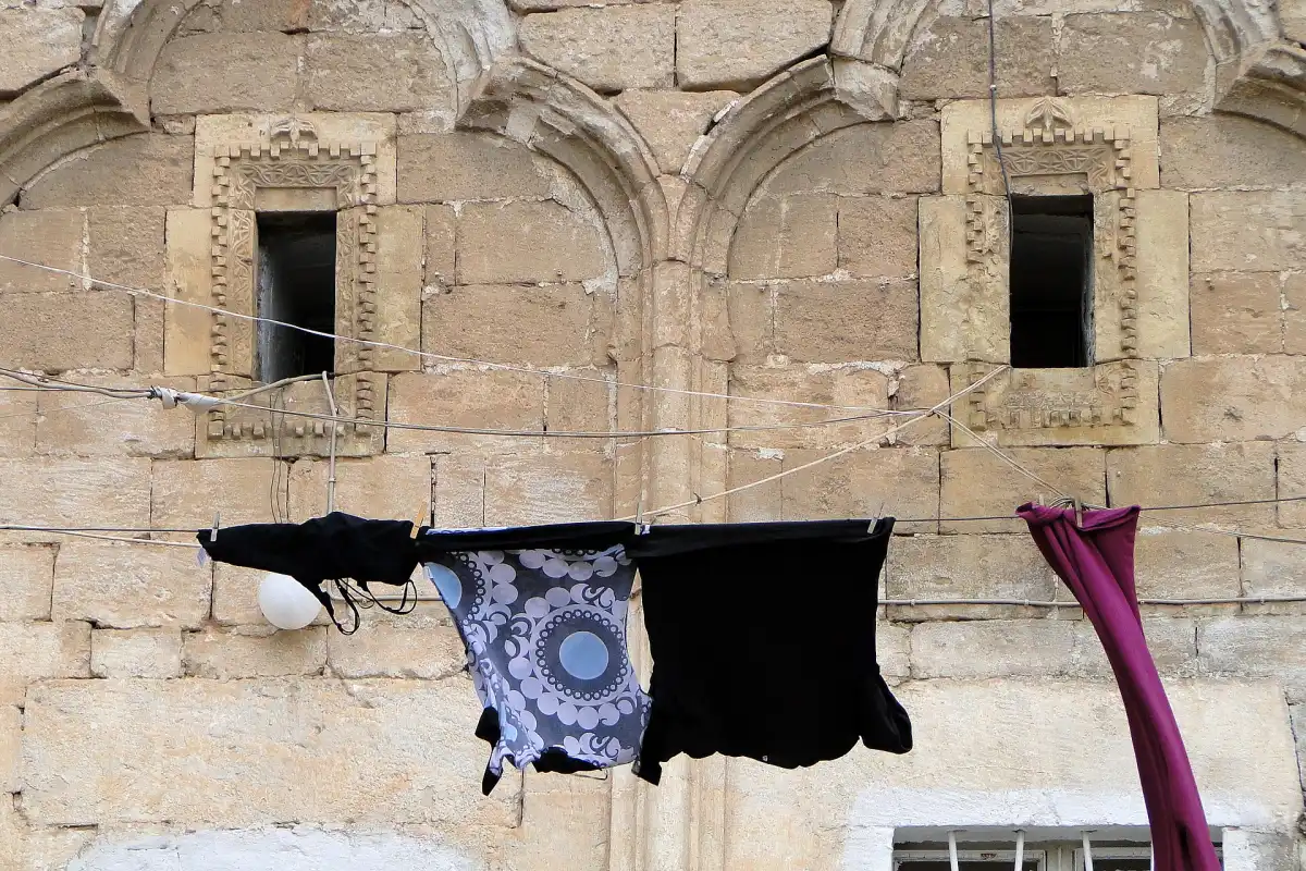 Façade en pierre calcaire sculptée d'une maison de Mardin avec du linge étendu