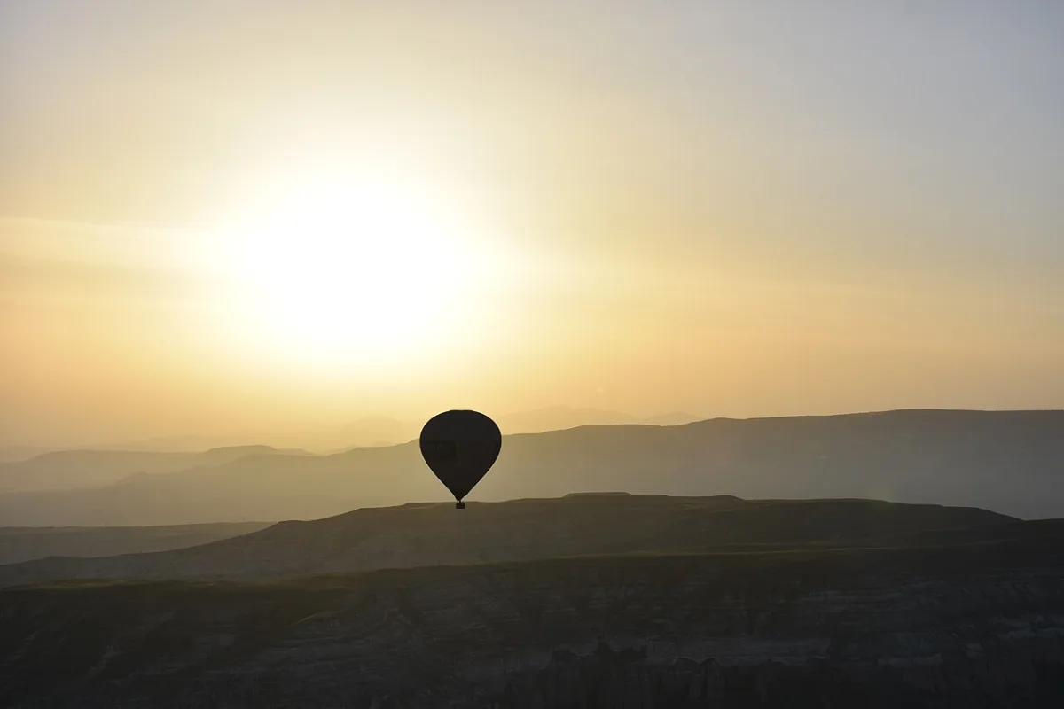 Montgolfière en silhouette au lever du soleil au-dessus des vallées de Cappadoce