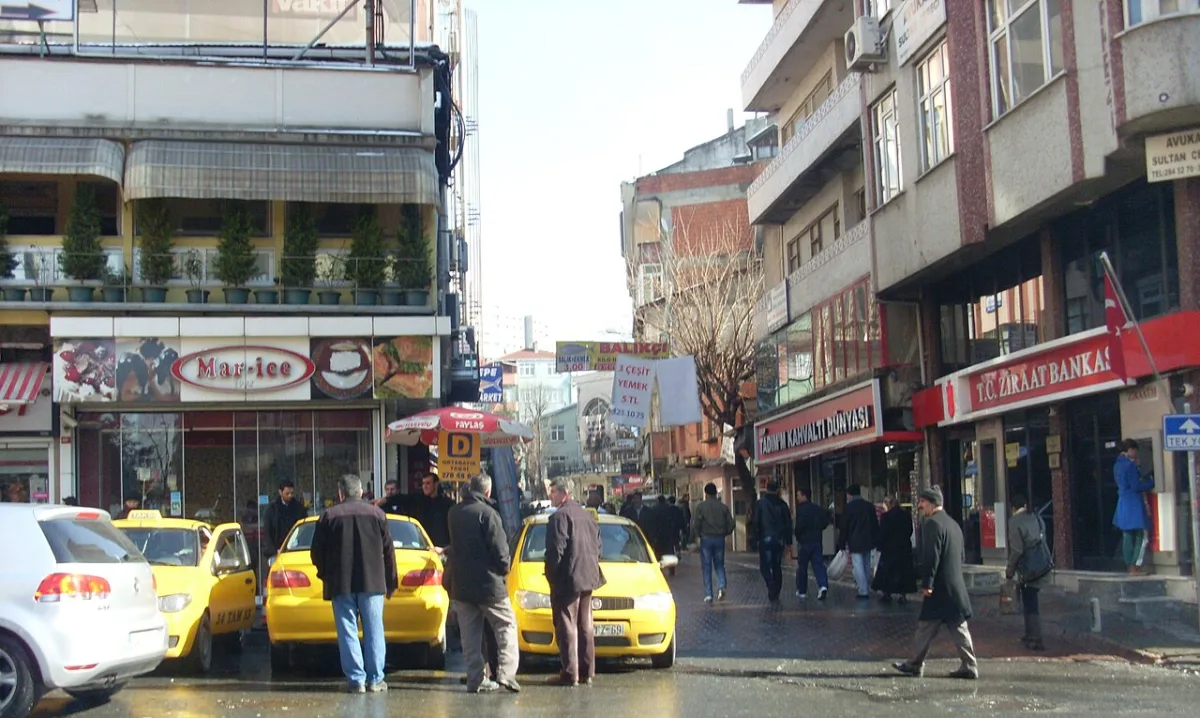 Taxis jaunes alignés dans une rue commerçante d'Istanbul, chauffeurs debout à côté des voitures