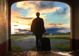 Voyageur tirant sa valise au moment du départ, au coucher du soleil